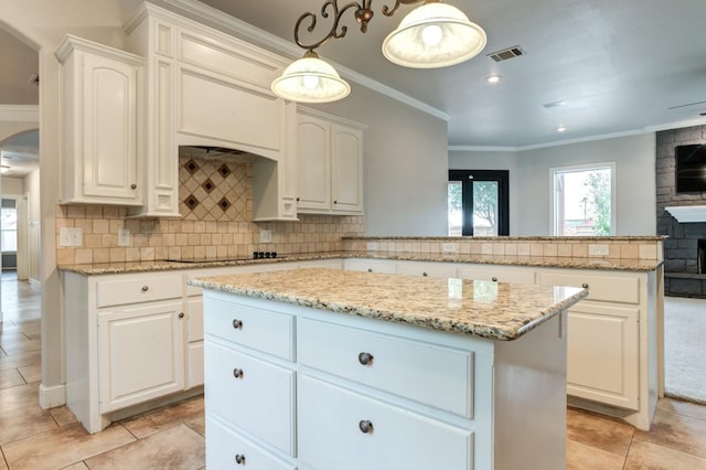 kitchen with pendant lighting, tasteful backsplash, white cabinets, and a kitchen island