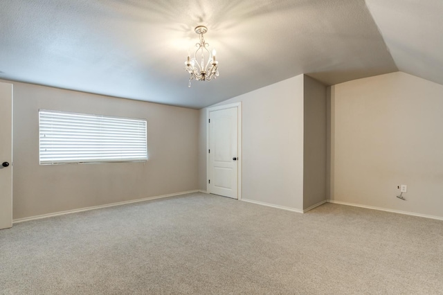 interior space with lofted ceiling, a textured ceiling, and a chandelier