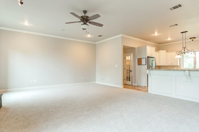 unfurnished living room with crown molding, light carpet, and ceiling fan