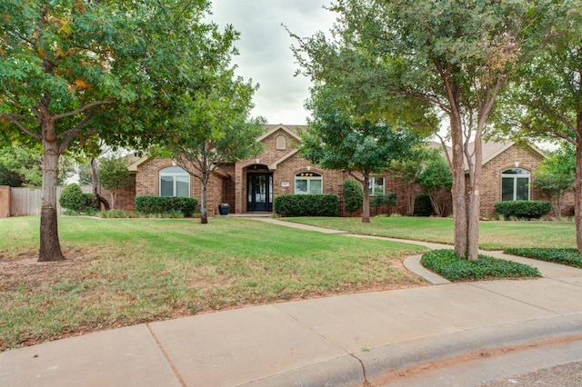 obstructed view of property with a front lawn