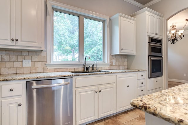 kitchen with white cabinetry, light stone counters, tasteful backsplash, and stainless steel appliances