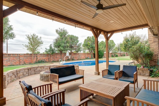 view of patio / terrace featuring ceiling fan, a fenced in pool, and an outdoor living space with a fire pit