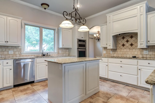 kitchen featuring pendant lighting, sink, appliances with stainless steel finishes, a center island, and white cabinets