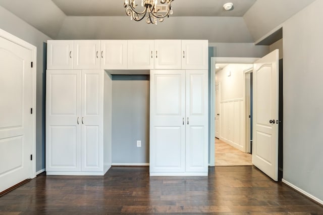 unfurnished bedroom featuring dark wood-type flooring, a chandelier, and vaulted ceiling