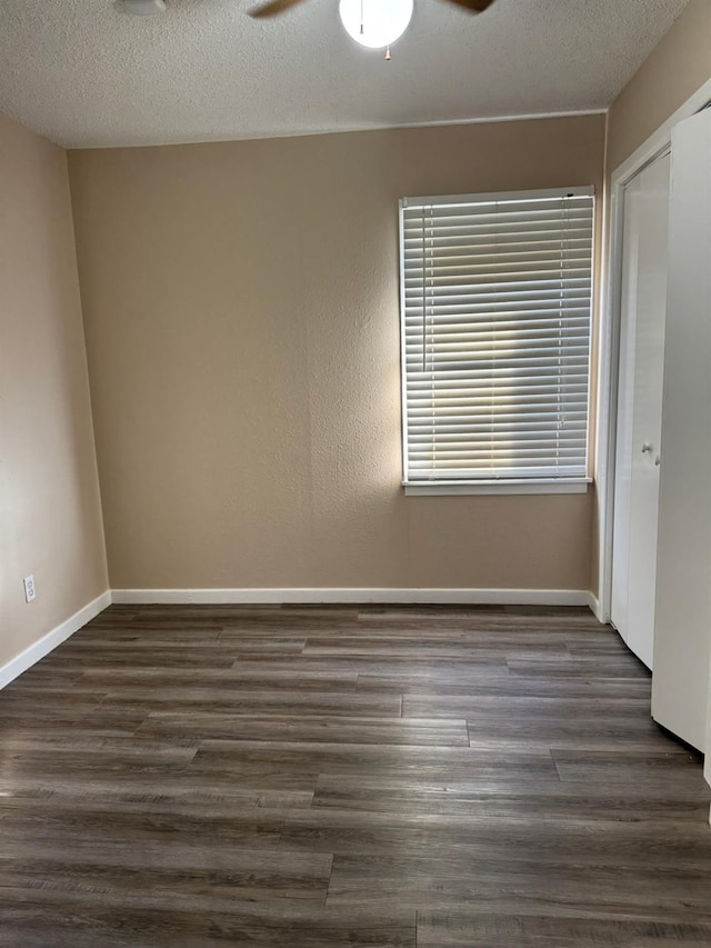 unfurnished room with dark hardwood / wood-style flooring, a textured ceiling, and ceiling fan