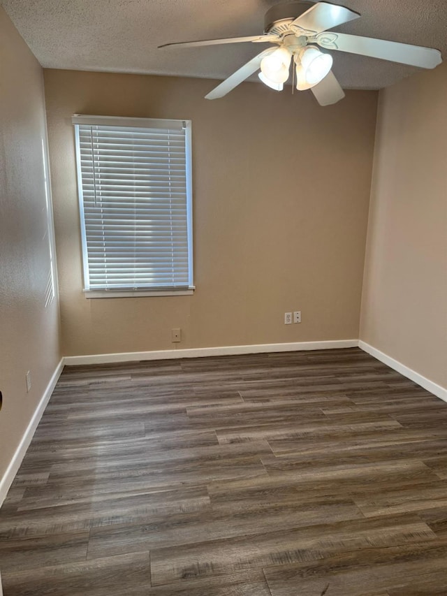 unfurnished room with ceiling fan, dark wood-type flooring, and a textured ceiling