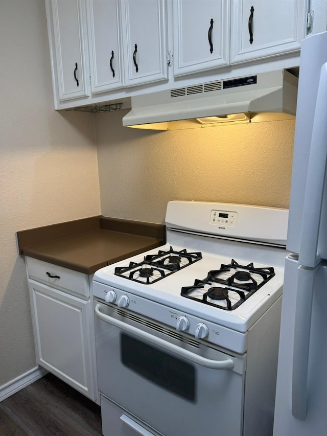 kitchen with white cabinetry, white appliances, and dark hardwood / wood-style floors