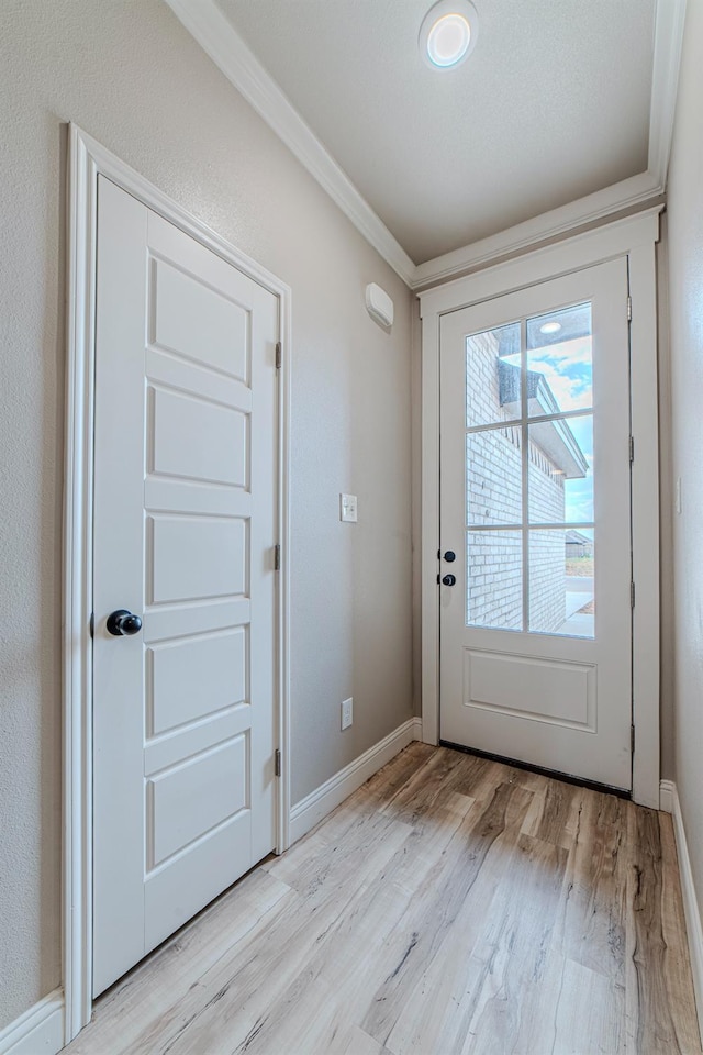 doorway with crown molding and light hardwood / wood-style floors