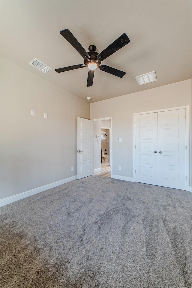 unfurnished bedroom with ceiling fan, carpet floors, and a closet