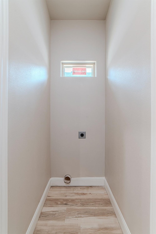 laundry area featuring light hardwood / wood-style floors and hookup for an electric dryer