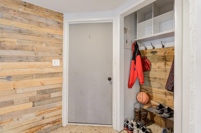 mudroom featuring ornamental molding and wooden walls