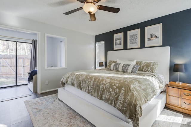 bedroom with access to exterior, a textured ceiling, light hardwood / wood-style flooring, and ceiling fan