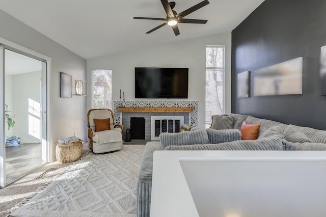 living room with ceiling fan, a fireplace, and vaulted ceiling