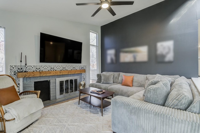 living room featuring ceiling fan and a fireplace