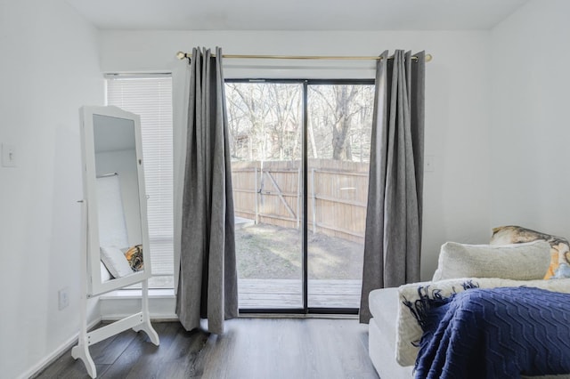 bedroom with dark hardwood / wood-style floors and access to outside