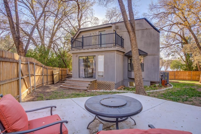 back of house featuring a balcony and a patio area