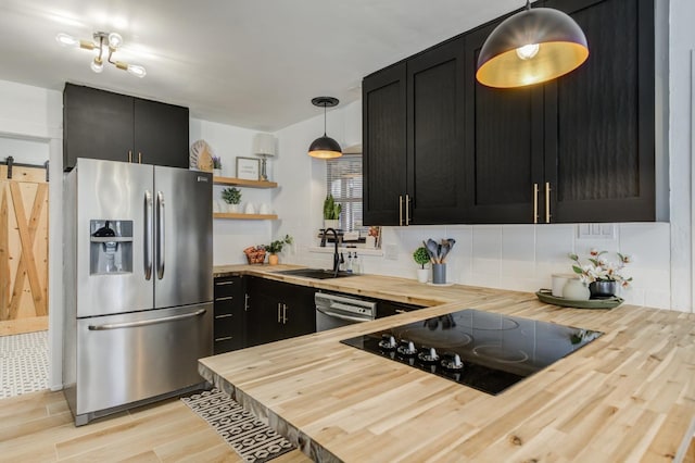 kitchen with wood counters, appliances with stainless steel finishes, and decorative light fixtures