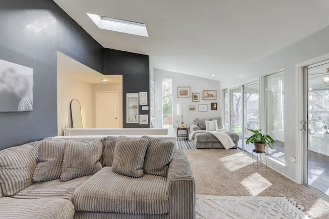 carpeted living room with lofted ceiling with skylight