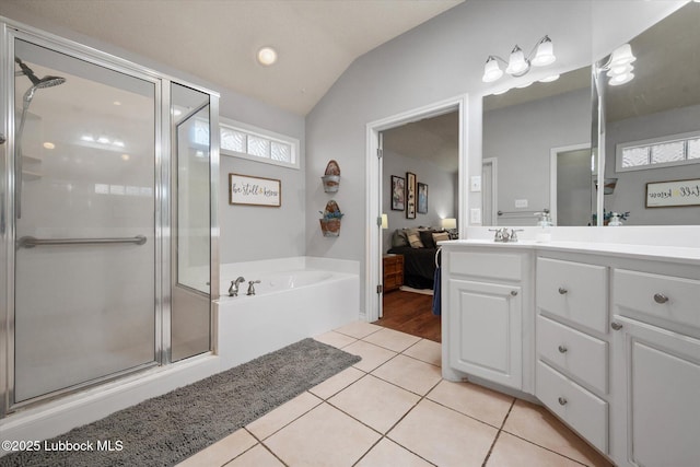 10401 Elgin Ave, Lubbock, TX 79423 - bathroom with vanity, a garden tub, tile patterned floors, a stall shower, and vaulted ceiling