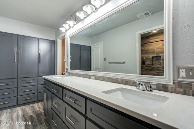 5734 92nd St, Lubbock, TX 79424 - bathroom featuring visible vents, a sink, wood finished floors, and double vanity