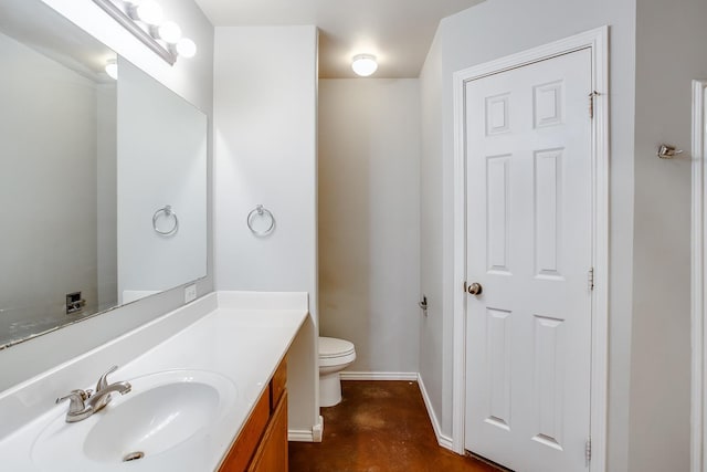 bathroom with vanity, concrete flooring, and toilet