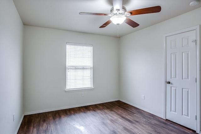 empty room featuring dark wood-type flooring and ceiling fan