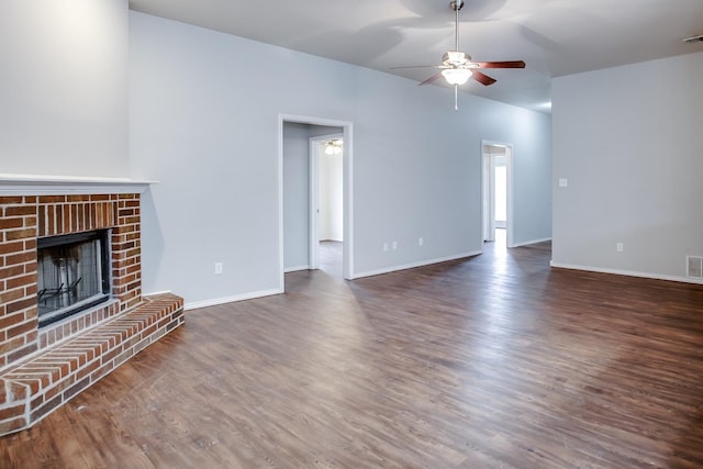 unfurnished living room with dark hardwood / wood-style floors, ceiling fan, and a fireplace