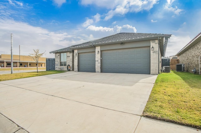 view of front of property featuring a garage, a front yard, and central air condition unit