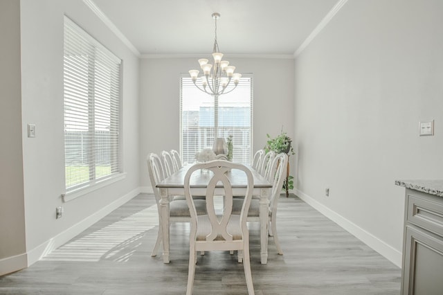 dining area with a notable chandelier, crown molding, and light hardwood / wood-style flooring