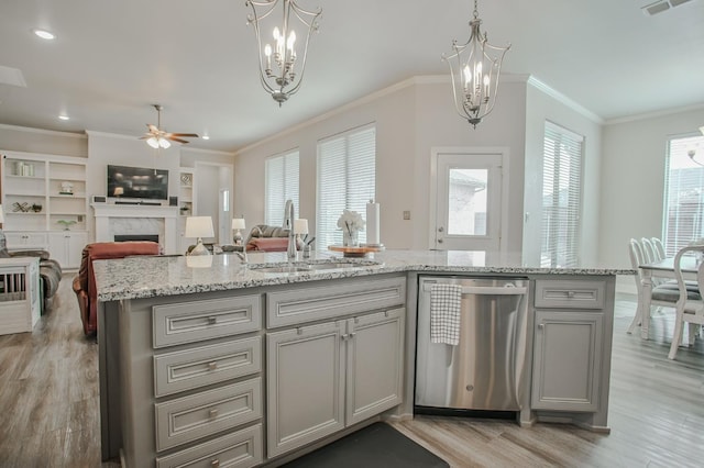 kitchen featuring sink, crown molding, decorative light fixtures, dishwasher, and an island with sink