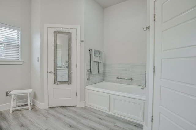 bathroom with hardwood / wood-style flooring and a tub