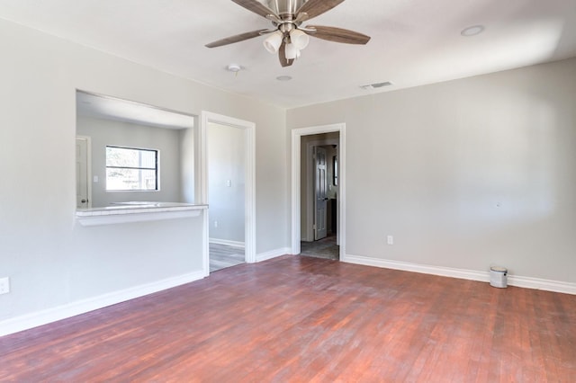 empty room with ceiling fan and dark hardwood / wood-style flooring