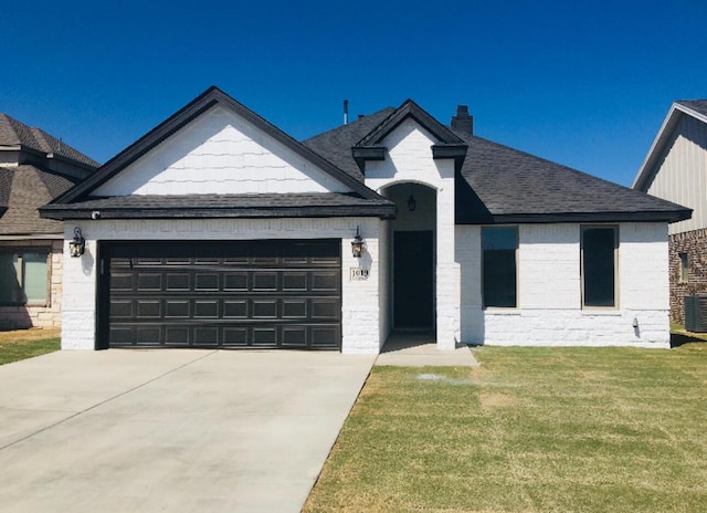 view of front of property featuring concrete driveway, a front yard, an attached garage, and brick siding