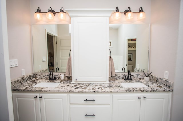 full bathroom featuring double vanity and a sink