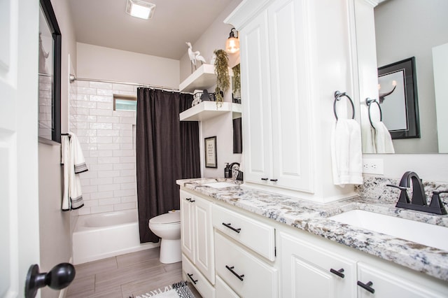full bathroom featuring shower / bathtub combination with curtain, toilet, double vanity, and a sink