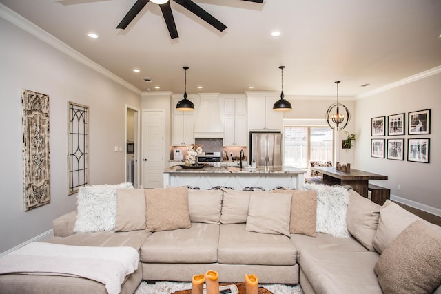 living area featuring baseboards, ornamental molding, recessed lighting, and ceiling fan with notable chandelier