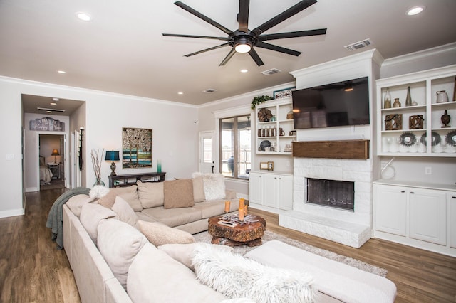 living room featuring visible vents, wood finished floors, a ceiling fan, and crown molding