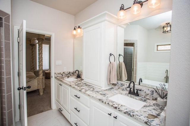 bathroom with double vanity, a tile shower, marble finish floor, and a sink