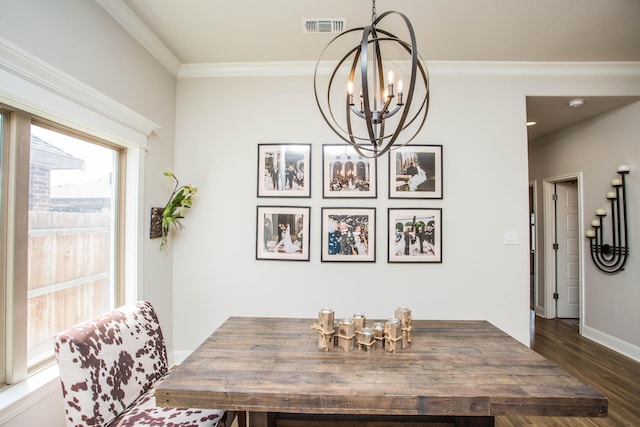 dining room featuring a notable chandelier, visible vents, baseboards, ornamental molding, and wood finished floors