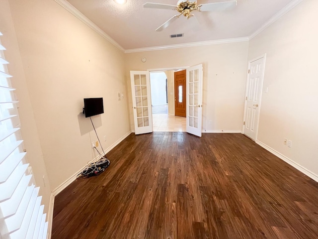 empty room featuring crown molding, dark hardwood / wood-style floors, french doors, and ceiling fan