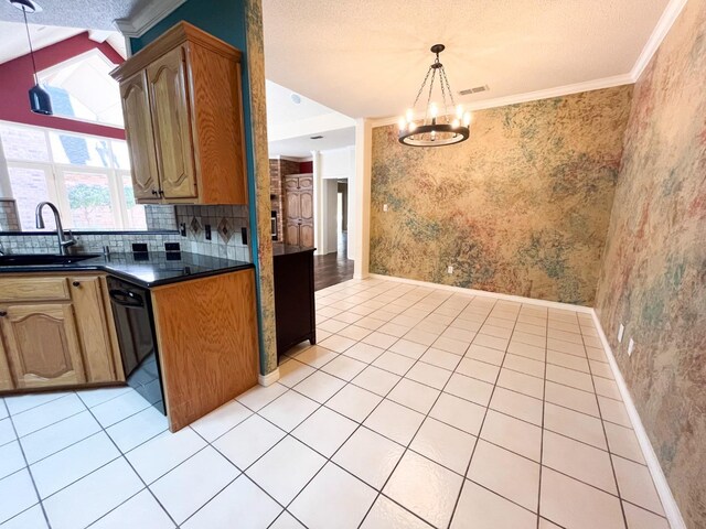 kitchen with light tile patterned flooring, black dishwasher, sink, and decorative light fixtures