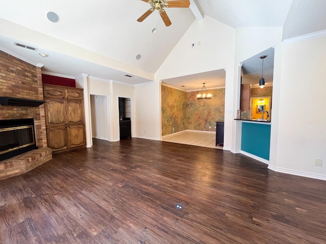 unfurnished living room featuring ceiling fan with notable chandelier, beamed ceiling, dark hardwood / wood-style flooring, ornamental molding, and a brick fireplace