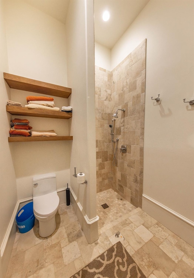 bathroom featuring tiled shower and toilet