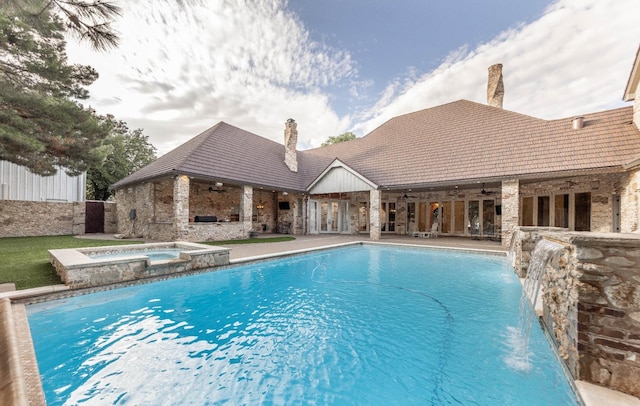 view of swimming pool with an in ground hot tub, pool water feature, ceiling fan, and a patio