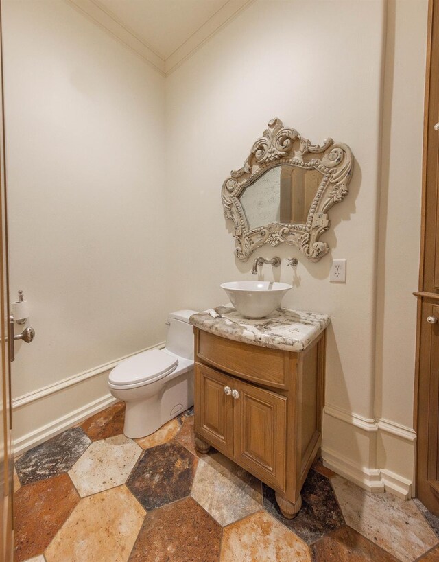 bathroom featuring ornamental molding, vanity, and toilet