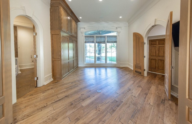 unfurnished room with crown molding and light wood-type flooring