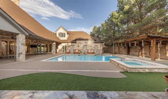 view of swimming pool featuring a fireplace, a patio, ceiling fan, and an in ground hot tub