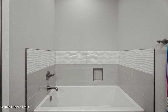 902 N Fulton Ave, Lubbock, TX 79416 - bathroom with a bath and a textured wall