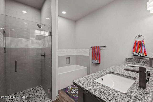 902 N Fulton Ave, Lubbock, TX 79416 - bathroom featuring double vanity, a stall shower, and wood finished floors
