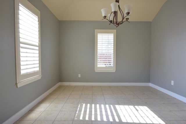 unfurnished room with an inviting chandelier, light tile patterned floors, and lofted ceiling